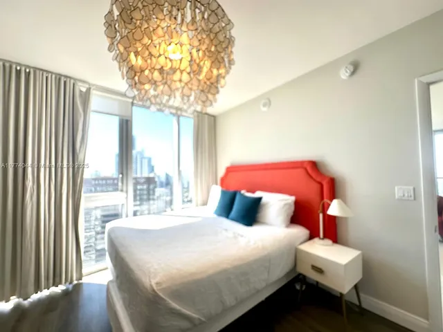 a bedroom with a bed and a chandelier