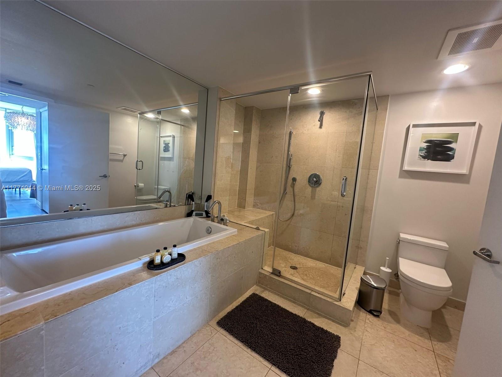 485 Brickell Avenue, Unit 4408 Miami, FL 33131 - Photo 10 of 15 a bathroom with a tub a toilet a sink and mirror