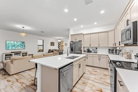 a large white kitchen with sink and microwave