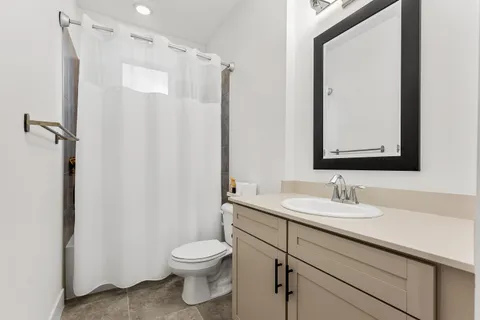 a bathroom with a granite countertop sink toilet and shower