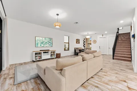 a living room with furniture and a wooden floor