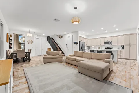 a living room with furniture and kitchen view