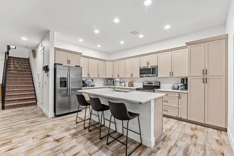 a kitchen with stainless steel appliances kitchen island granite countertop a refrigerator and a stove top oven