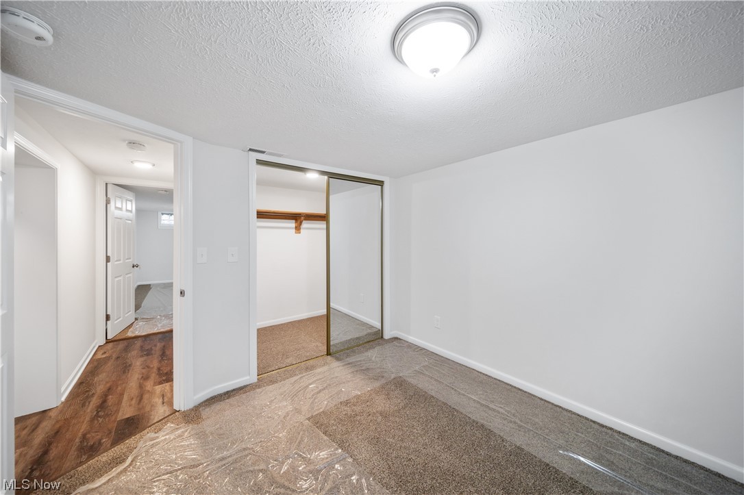 684 Sterling Road Wickliffe, OH 44092 - Photo 29 of 35 Unfurnished bedroom with a closet, dark hardwood / wood-style flooring, and a textured ceiling