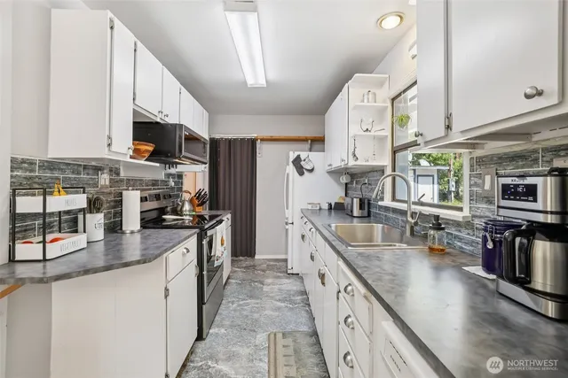 a large kitchen with stainless steel appliances granite countertop a lot of counter space cabinets and a stove