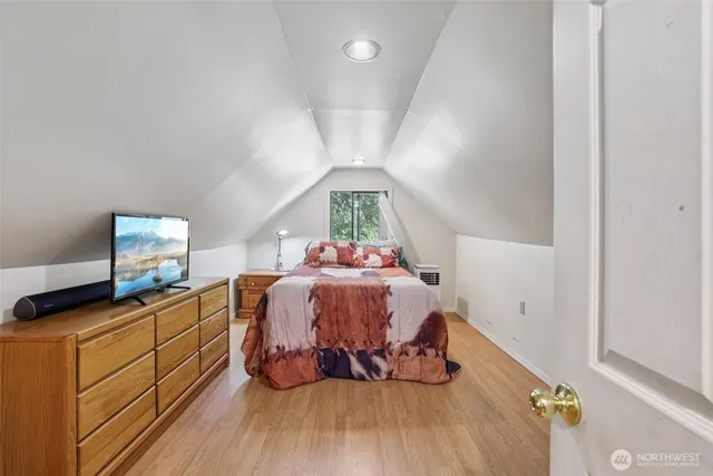 a bedroom with a bed and wooden floor