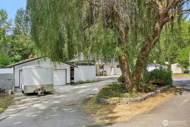 a view of a house with backyard and trees