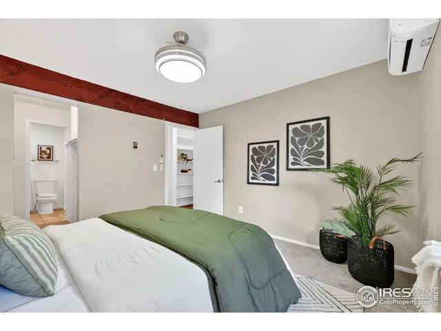 a bedroom with a large bed and a potted plant