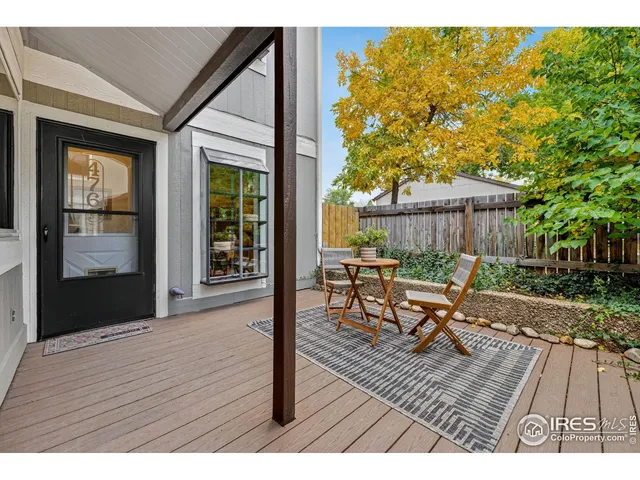 a view of a patio with table and chairs with wooden floor and fence