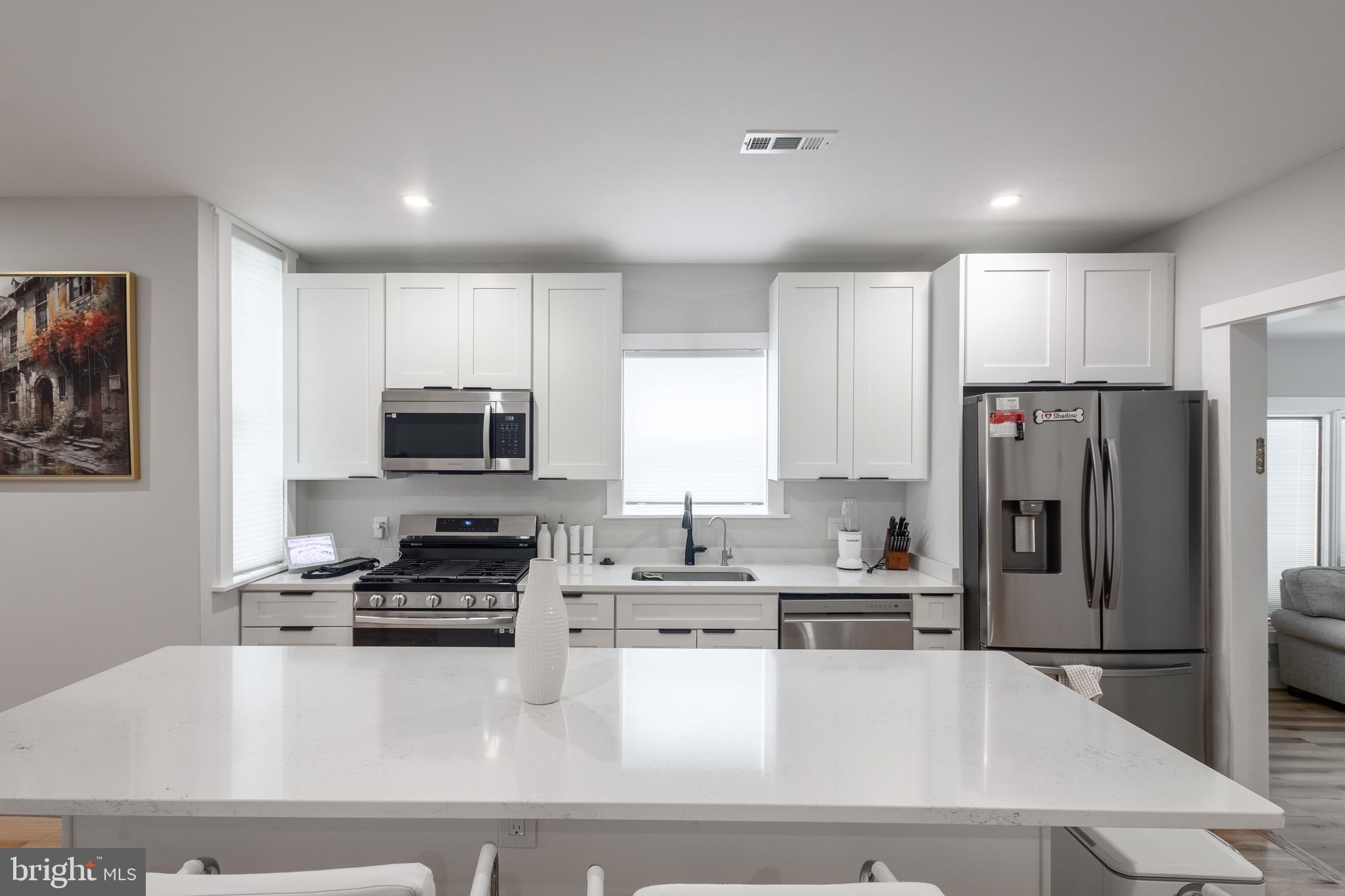 37 4th Street Laurel, MD 20707 - Photo 1 of 26 a kitchen with kitchen island a refrigerator a stove a microwave and cabinets
