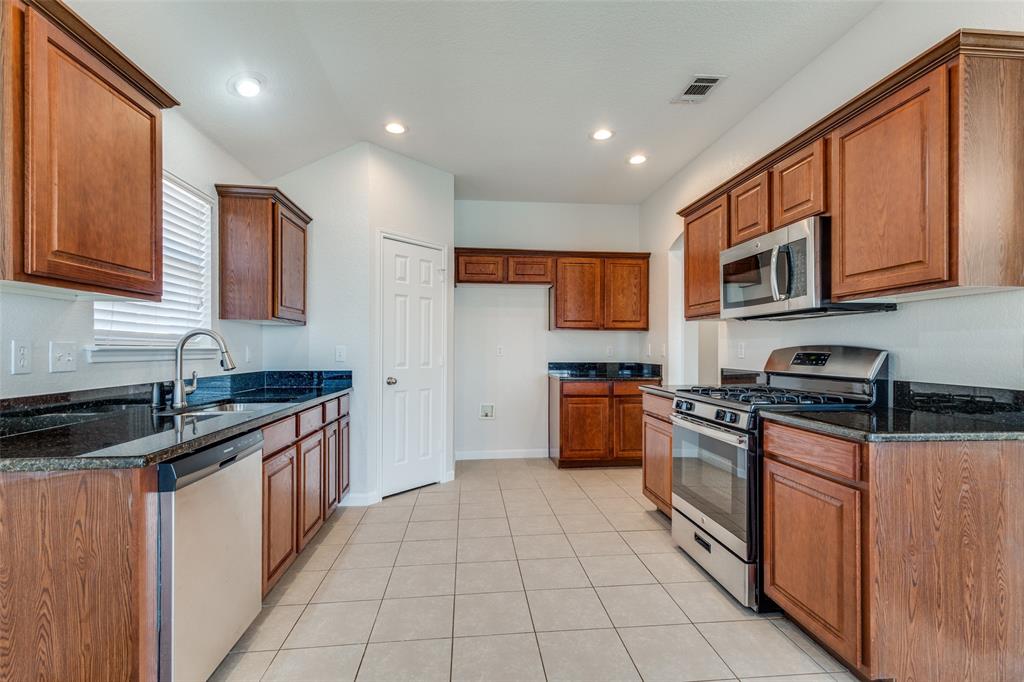 1257 Barrel Run Fort Worth, TX 76052 - Photo 10 of 29 a kitchen with stainless steel appliances granite countertop a stove sink and cabinets