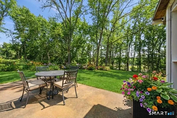 a view of a table and chairs in back yard of the house