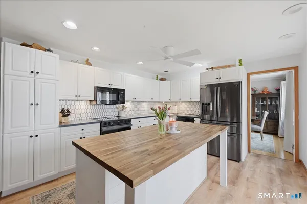 a kitchen with stainless steel appliances granite countertop a sink refrigerator and microwave