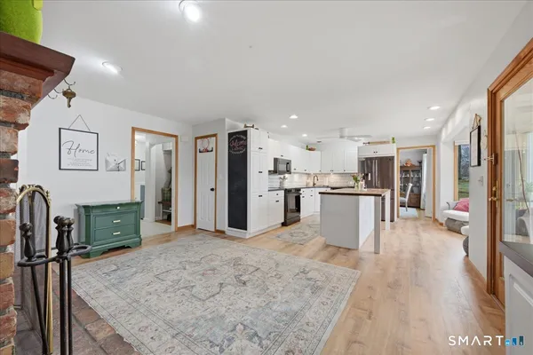 a kitchen with granite countertop a sink stainless steel appliances and white cabinets