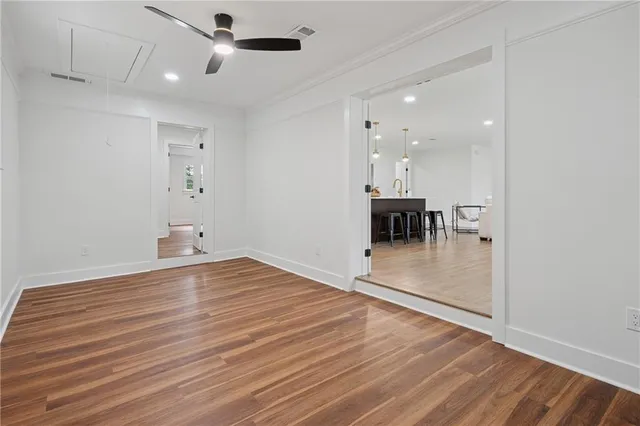 a view of a room with wooden floor and a ceiling fan