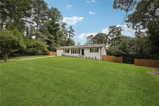 a view of a house with backyard and trees