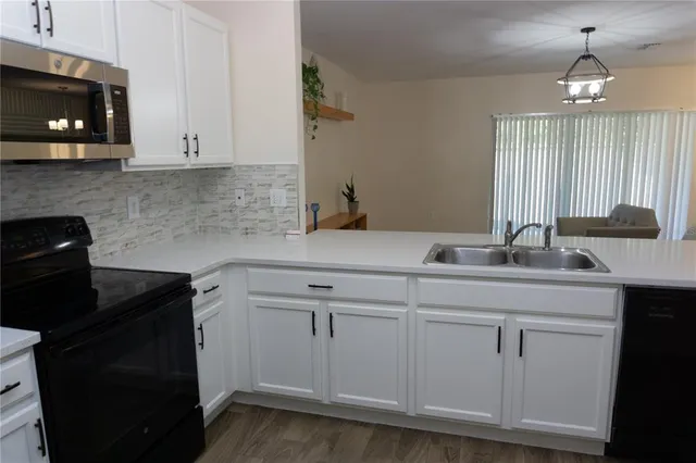 a kitchen with white cabinets a sink and dishwasher