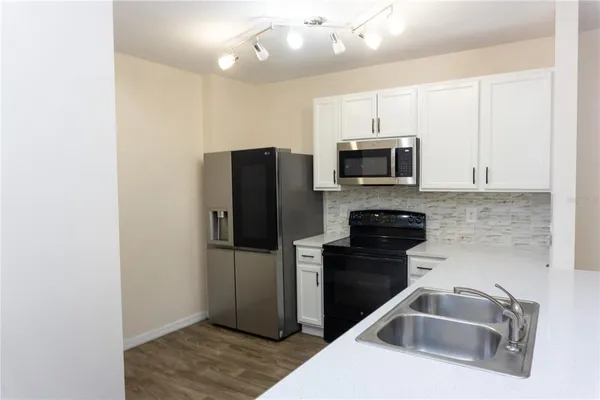 a kitchen with a refrigerator sink and microwave