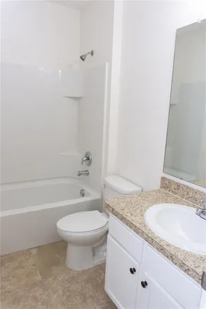 a bathroom with a toilet and a bath tub