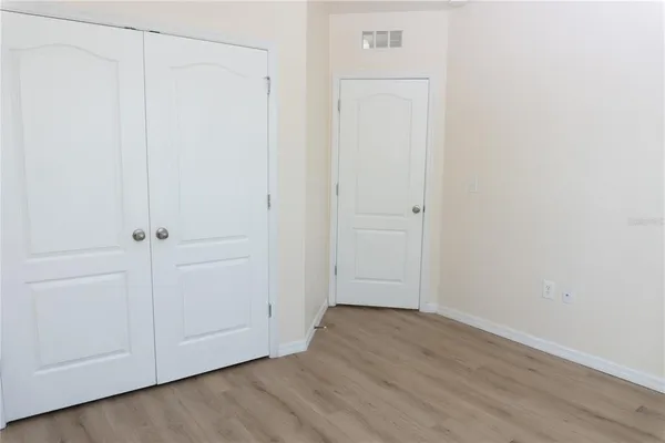 a view of a hallway with closet and wooden floor