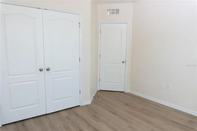 a view of a hallway with closet and wooden floor
