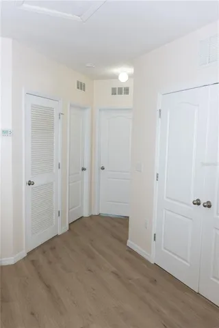 a view of a hallway with wooden floor