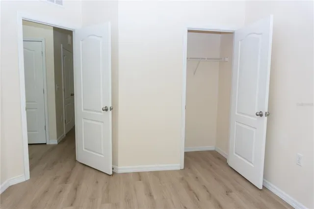 a view of an empty room with cabinet and mirrors