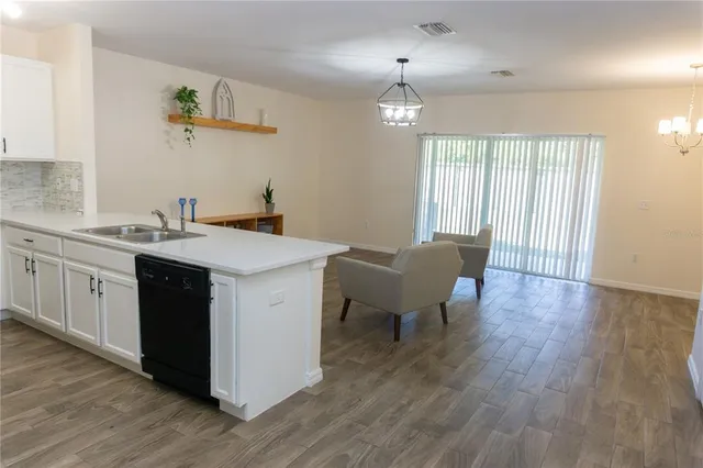 a kitchen with a sink cabinets and wooden floor