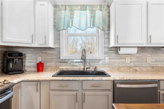 a kitchen with white cabinets and a sink