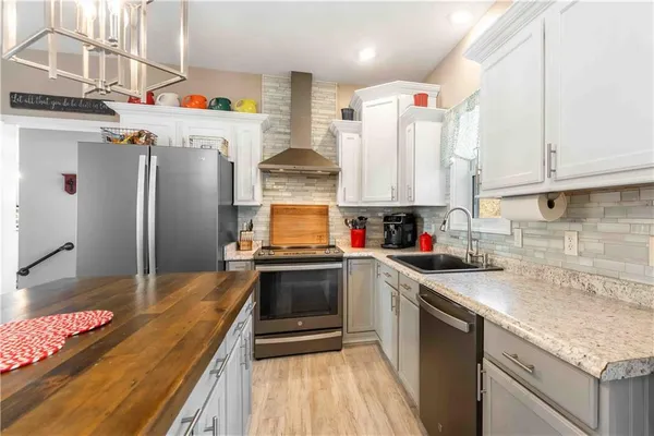 a kitchen with stainless steel appliances granite countertop a kitchen island a stove and a sink