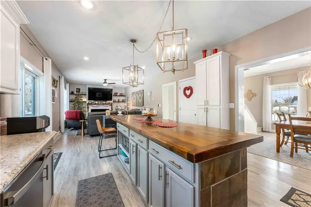 a kitchen with stainless steel appliances granite countertop a kitchen island a stove and a sink