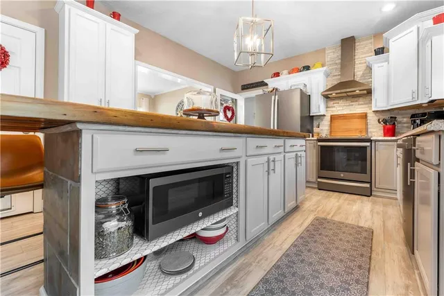 a kitchen with stainless steel appliances a stove microwave and cabinets