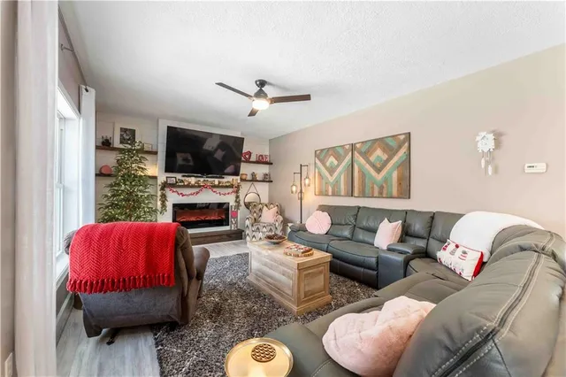 a living room with furniture a flat screen tv and a fireplace