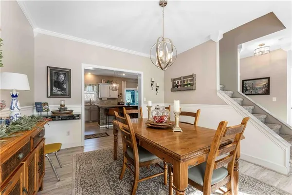 a kitchen with stainless steel appliances granite countertop a sink a stove a refrigerator cabinets and chairs