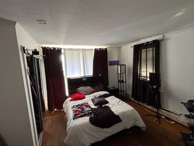 a bedroom with a bed closet and a flat tv screen