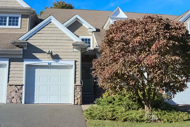 a view of a house with a tree and a yard