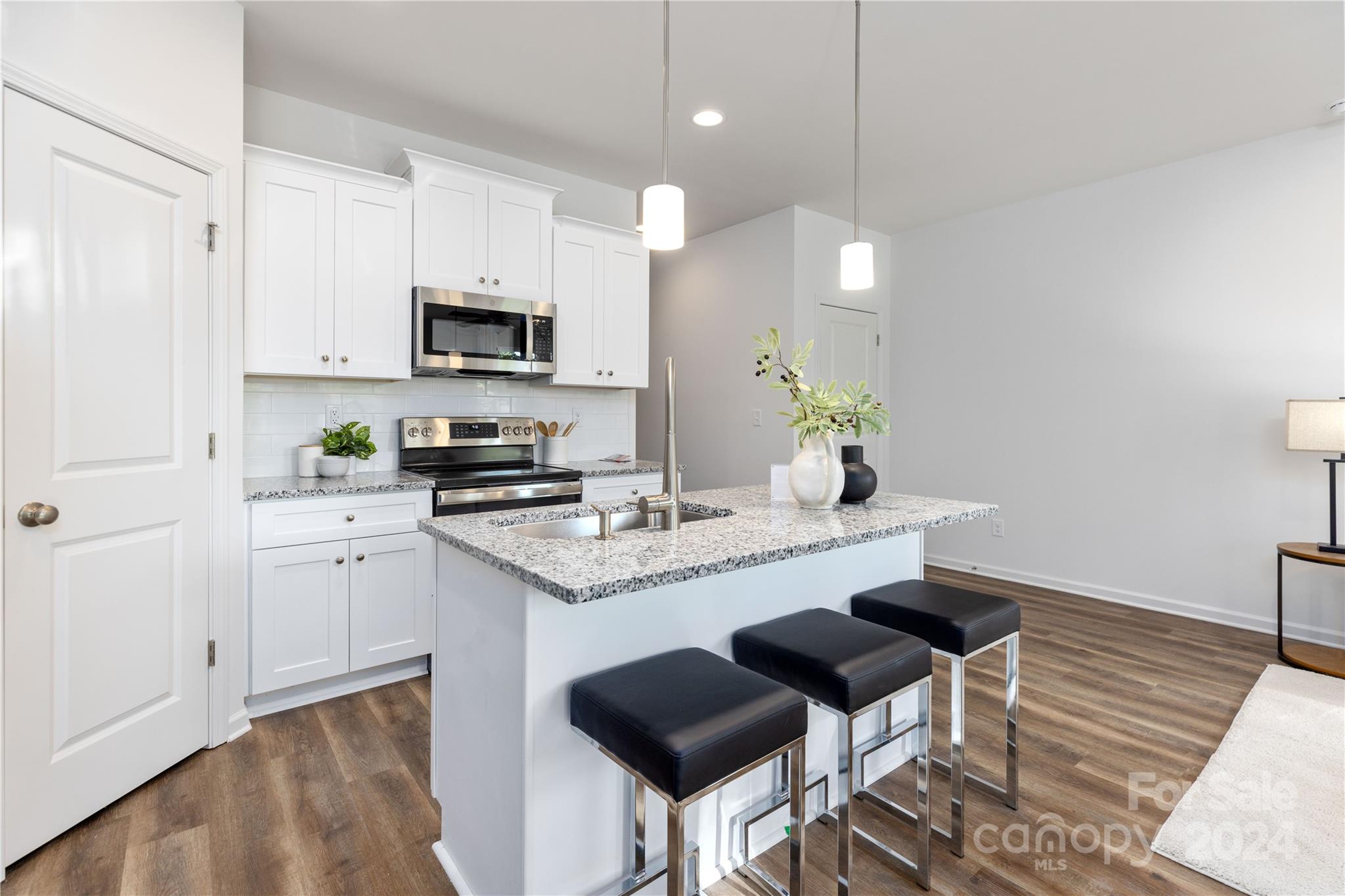 4329 Perkins Road Charlotte, NC 28269 - Photo 8 of 28 a kitchen with stainless steel appliances granite countertop a stove a sink a microwave a refrigerator and white cabinets