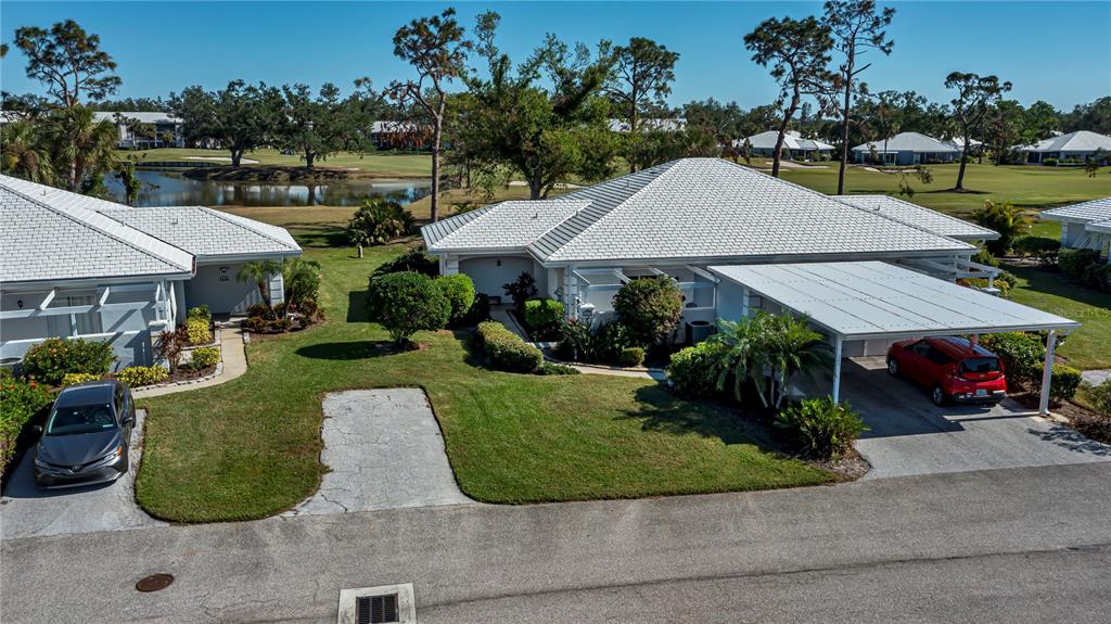 an aerial view of a house with garden space and lake view in back