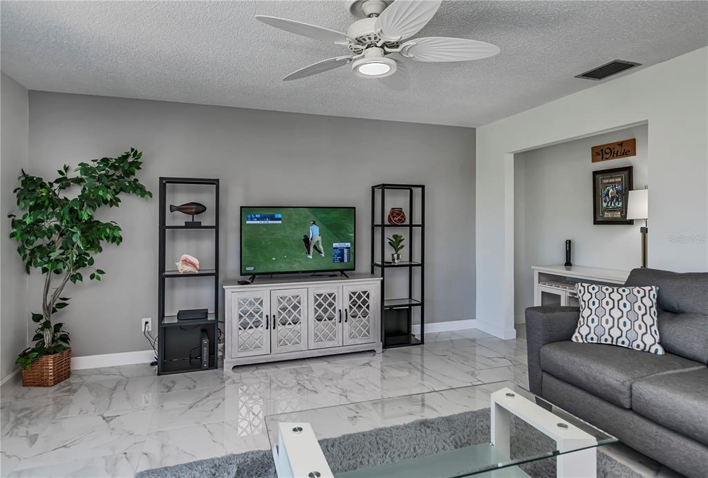 262 Cerromar Way South, Unit 53 Venice, FL 34293 - Photo 14 of 59 a living room with furniture and a flat screen tv