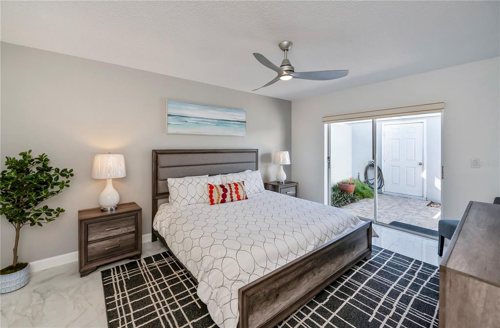 262 Cerromar Way South, Unit 53 Venice, FL 34293 - Photo 29 of 59 a bedroom with a large bed and a chandelier