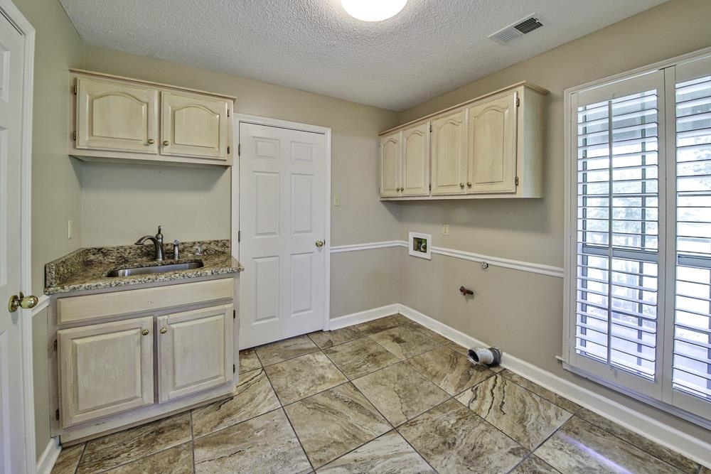 3693 Brunswick Road Bartlett, TN 38133 - Photo 21 of 30 Washroom with sink, cabinets, light tile patterned floors, a textured ceiling, and washer hookup