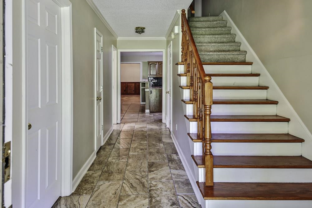 3693 Brunswick Road Bartlett, TN 38133 - Photo 23 of 30 Staircase with crown molding, dark tile patterned flooring, and a textured ceiling