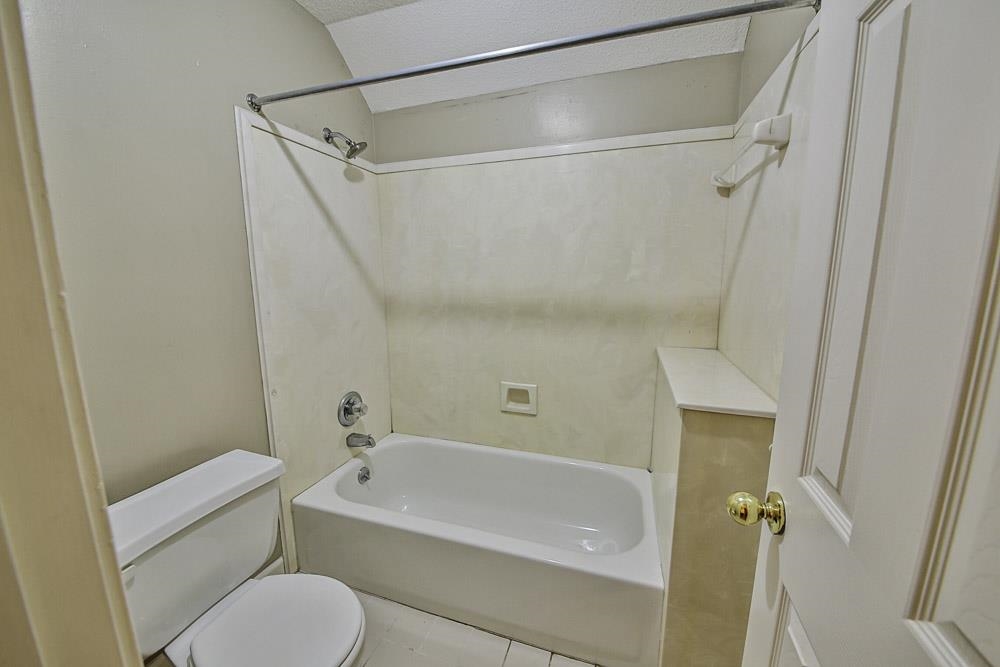 3693 Brunswick Road Bartlett, TN 38133 - Photo 28 of 30 Bathroom featuring shower / washtub combination, toilet, tile patterned floors, and a textured ceiling