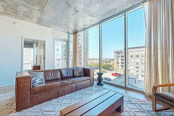 a living room with furniture and a floor to ceiling window