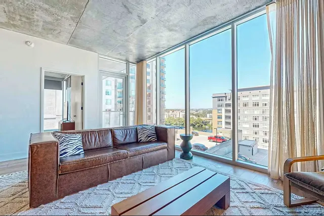 a living room with furniture and a floor to ceiling window
