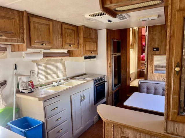 a kitchen with a refrigerator a sink dishwasher with a dining table and chairs