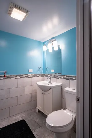 a bathroom with a toilet sink and mirror