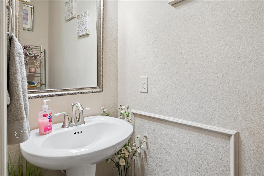 8268 Kara Creek Road Frisco, TX 75036 - Photo 18 of 31 Pedestal sink with brushed nickel faucet, framed wall mirror, and decorative wall paneling