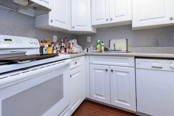 a kitchen with white cabinets and white appliances