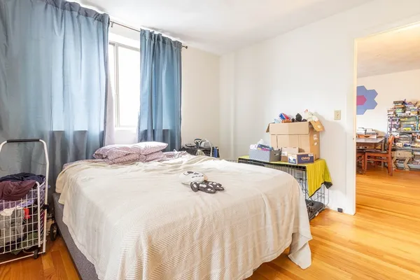 a bedroom with a bed and wooden floor